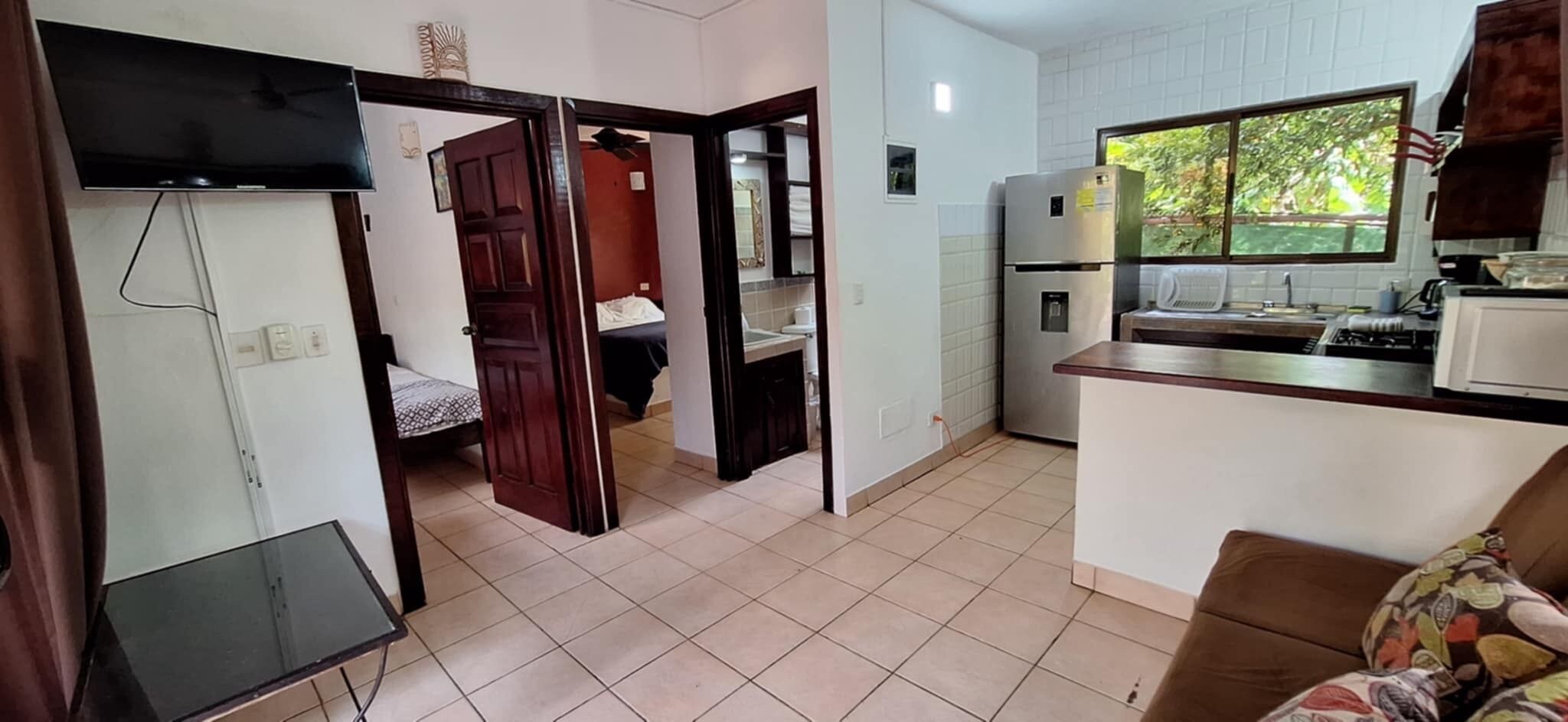 A compact living space with a kitchenette, a bed, and a dining area.