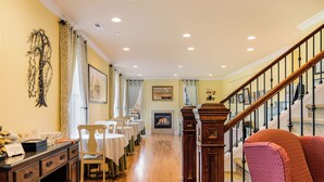 A hotel lobby with a wooden staircase, a fireplace, and a dining area with tables and chairs. - La Bastide Bed & Breakfast (Dundee)