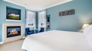 A bedroom with a large bed, a fireplace, a television, and a view of the outdoors through the windows. - La Bastide Bed & Breakfast (Dundee)
