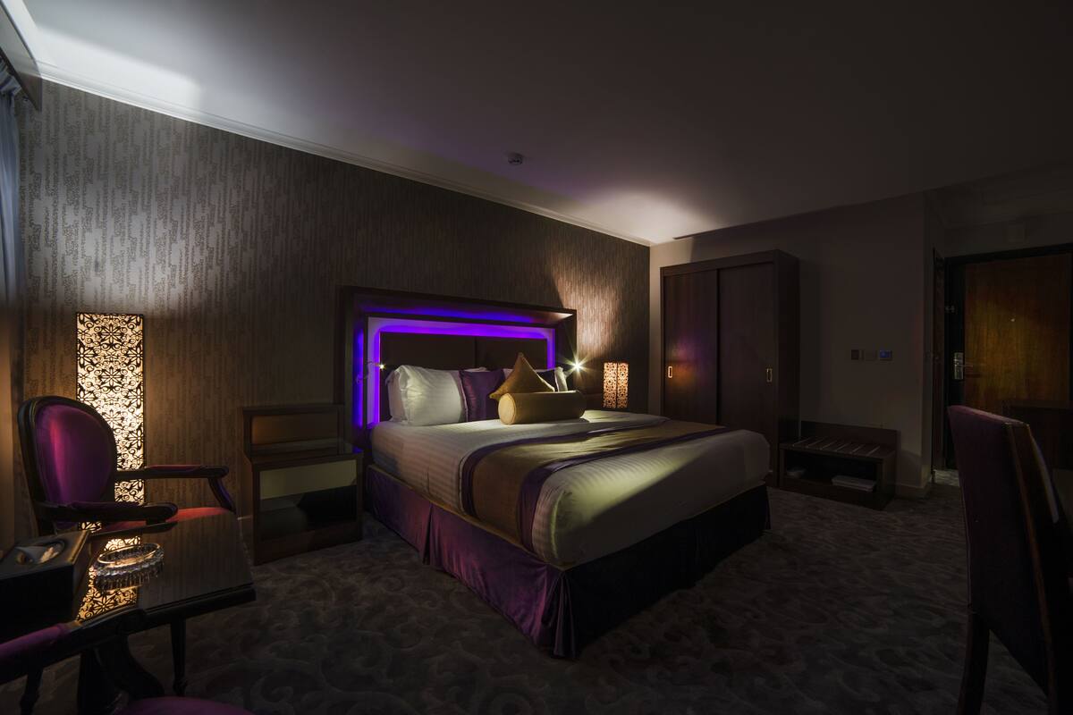 Moderni hotellihuone, jossa on suuri sänky, työpöytä ja tuoli.
