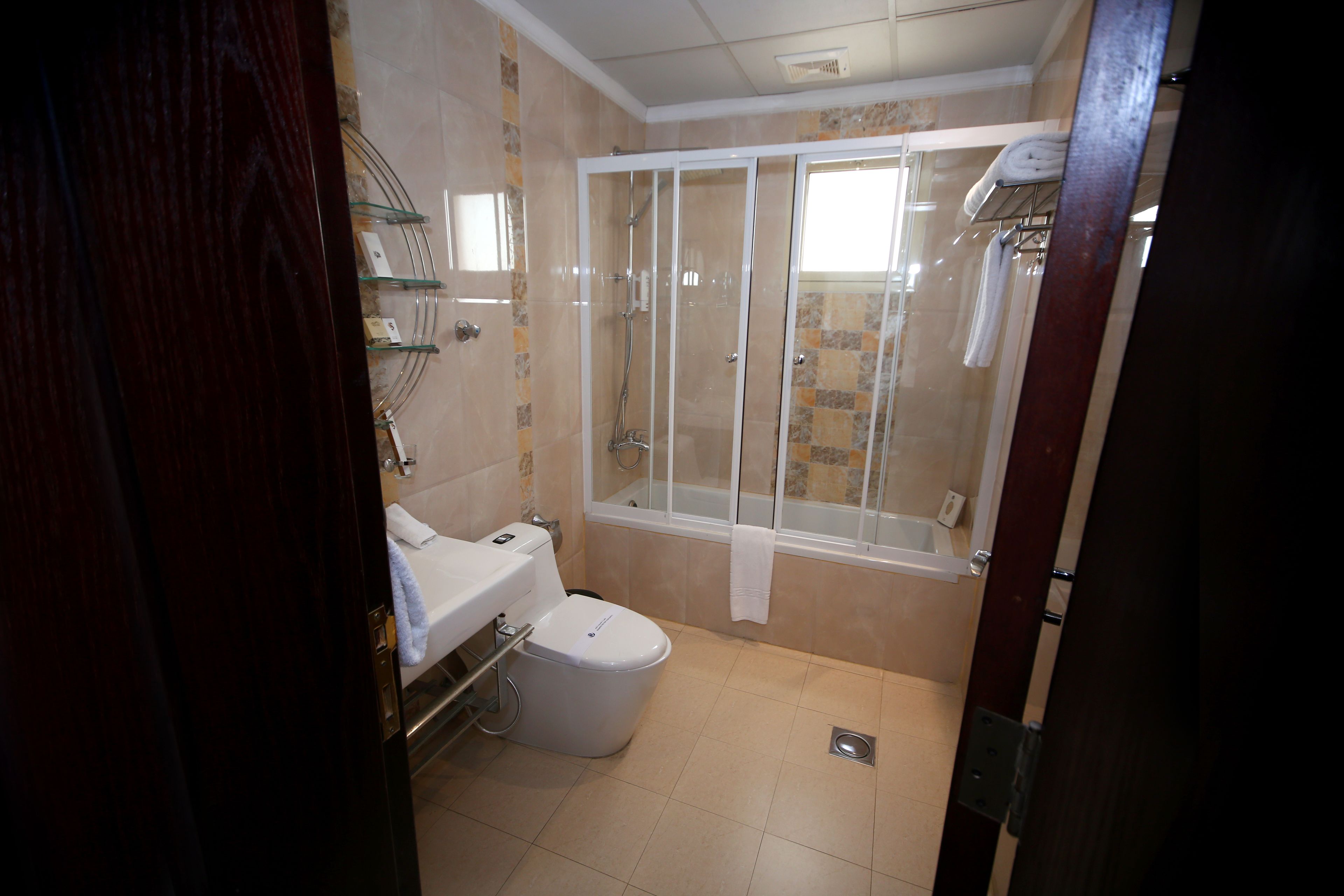 A bathroom with a toilet, sink, shower, and bathtub.