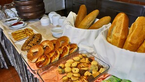 Un bufé con diversas opciones de comida, como pan, bollería y galletas.