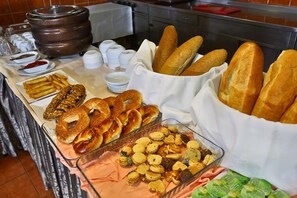 Ein reichhaltiges Buffet mit verschiedenen Speisen, darunter Brot, Gebäck und Kekse.