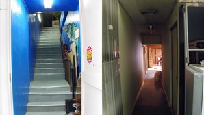 A hallway with a staircase leading to an upper floor. - Kimono Inn Utakata - Hostel (Himeji)