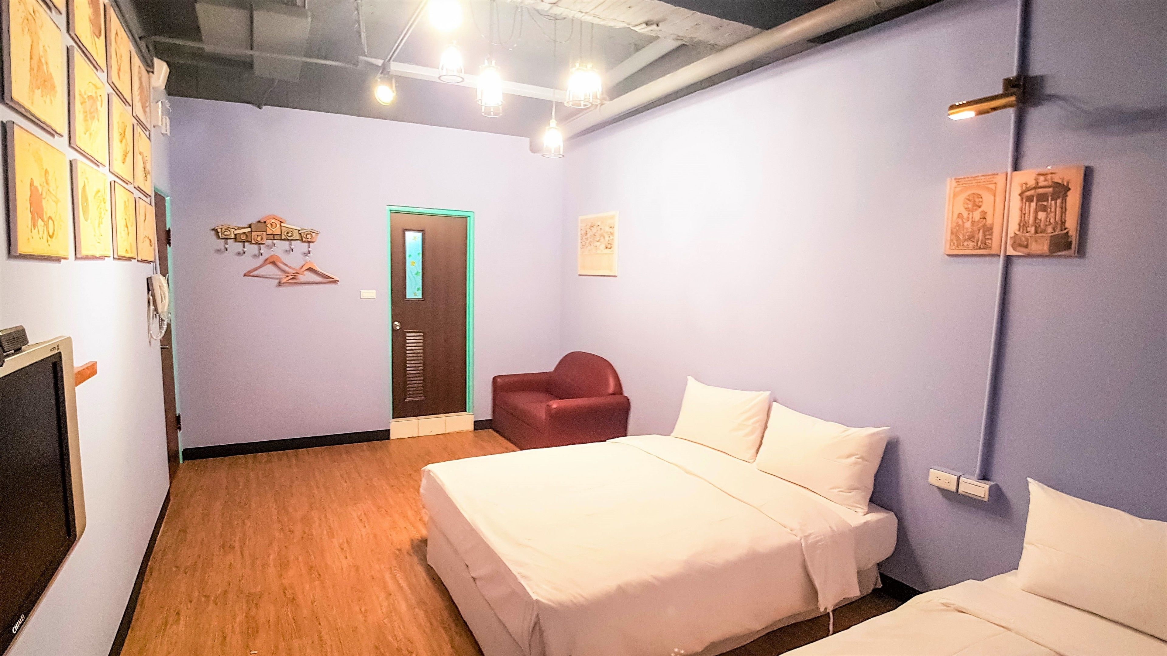 Una habitación de hotel con una cama, una silla y un armario.