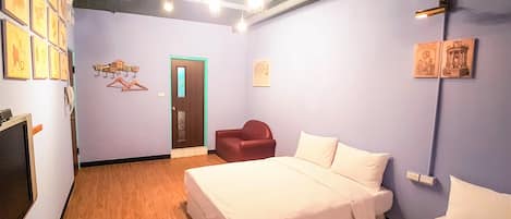 Una habitación de hotel con una cama, una silla y un armario.