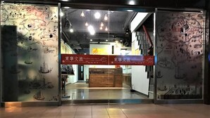 La entrada al Hotel DongNing Atlas, con un mostrador de recepción y un cartel encima.