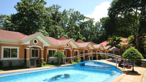 Una piscina al aire libre, sombrillas, tumbonas