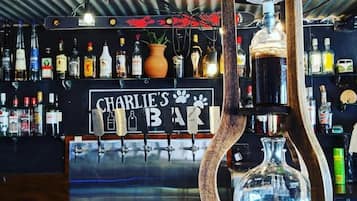 A bar with a sign reading 'CHARLIE'S BAR' and a variety of liquor bottles.