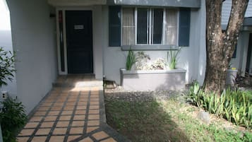 Welcome to a beautifully maintained residence with a clean design, featuring a garden and a tiled walkway.