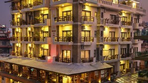 A multi-story hotel with balconies, a ground-level restaurant, and a sign indicating it is a luxury resort. - Kuti Resort and Spa (Pokhara)