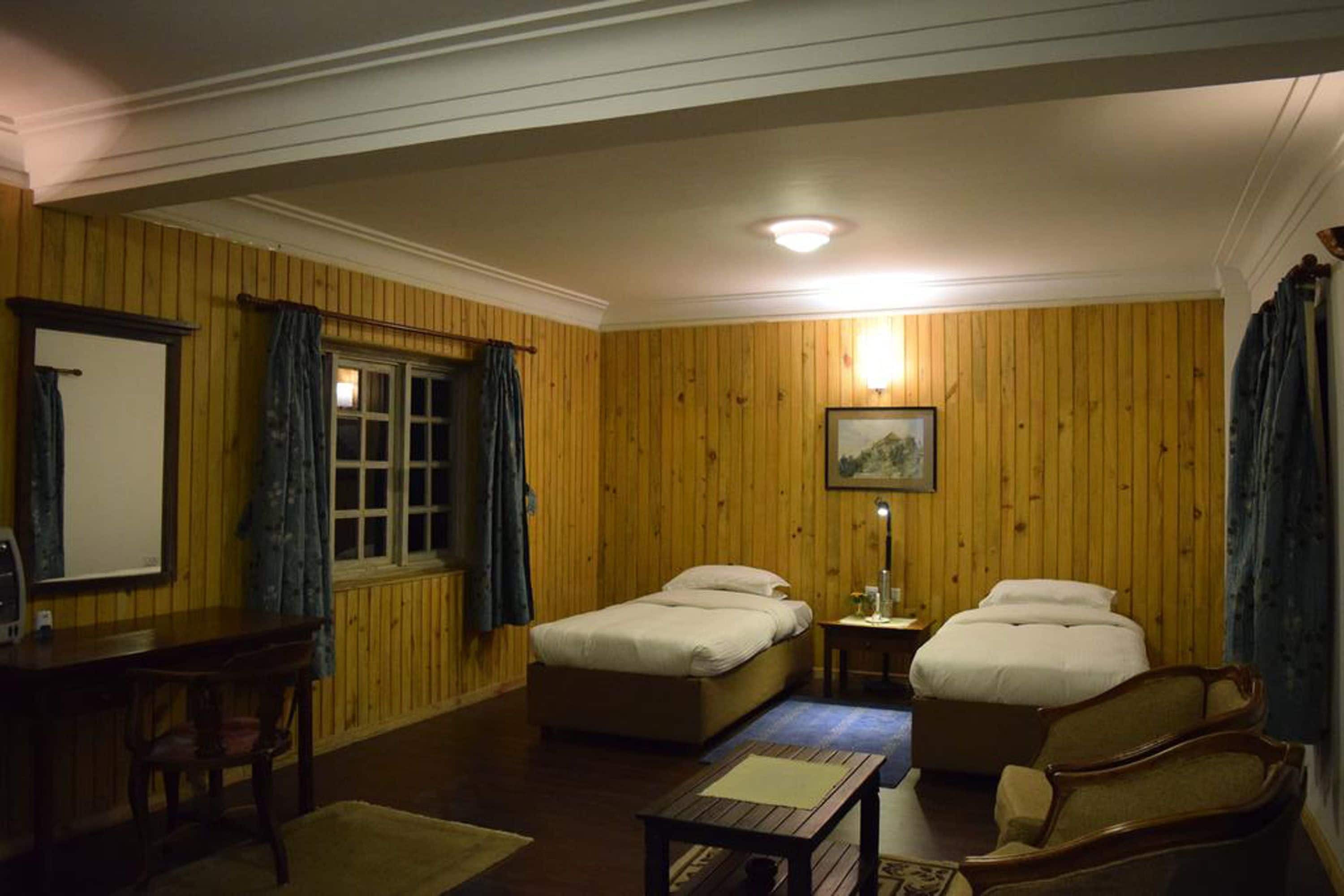 A room with two beds, a desk, and a chair.