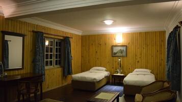 A room with two beds, a desk, and a chair.