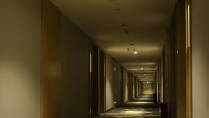 A long, narrow hallway with a patterned carpet and a series of doors on both sides. - ECHARM Hotel Zhengzhou High Tech Zone (Zhengzhou)