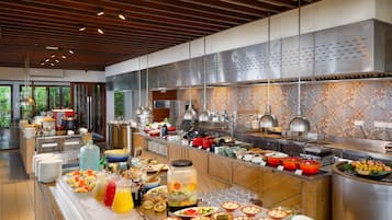 Un buffet proposant une variété de plats et de boissons, une grande hotte de cuisine en acier inoxydable et un design de cuisine moderne.