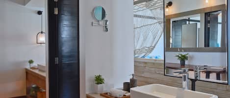 Un baño moderno con un espejo grande, un lavabo blanco y un mueble de tocador de madera.