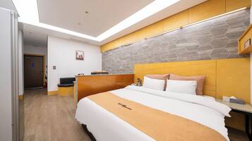 Una habitación de hotel moderna con una cama grande, un cabecero de madera, una pared con diseño de piedra y un tragaluz.