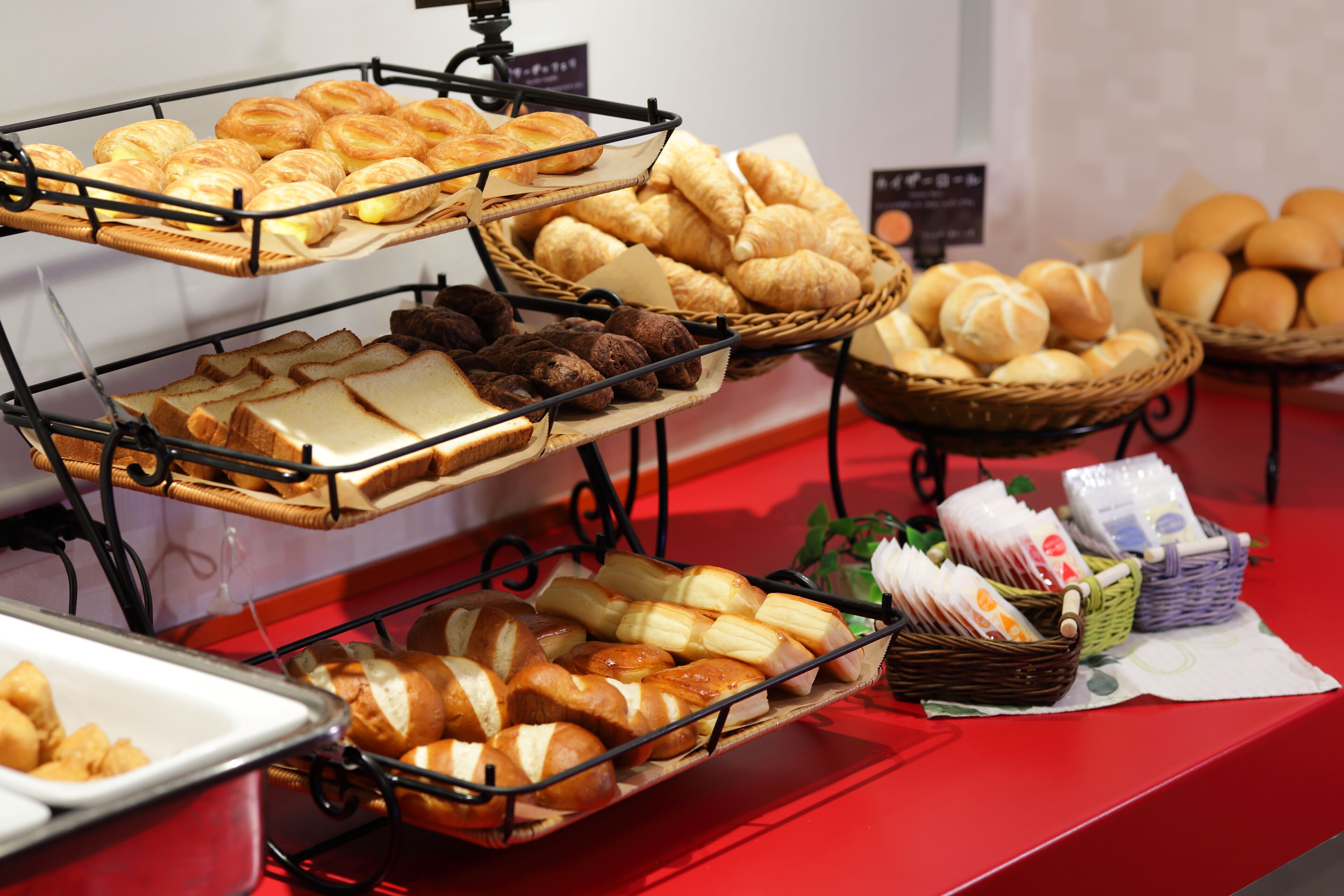 Mostrador de panadería con panes y pasteles varios.
