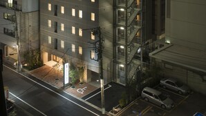 A multi-story hotel with a prominent staircase and illuminated windows. - Hotel Guest1 Ueno Ekimae (Tokyo)