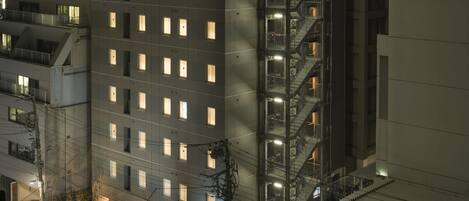 A multi-story hotel with a prominent staircase and illuminated windows.