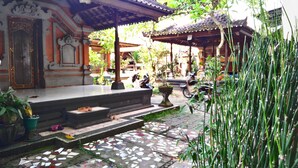A traditional building with a tiled entrance, steps leading up to a porch, and a tiled pathway. - Nyoman Badri Homestay (Ubud)
