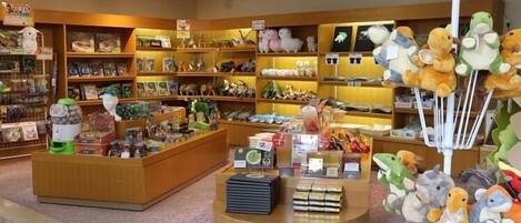 A store interior with wooden shelves stocked with toys and plush toys.