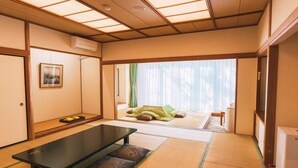 A traditional Japanese room with tatami flooring, a low table, and sliding doors leading to a balcony. - Hotel Blancvert Nasu (Nasu)