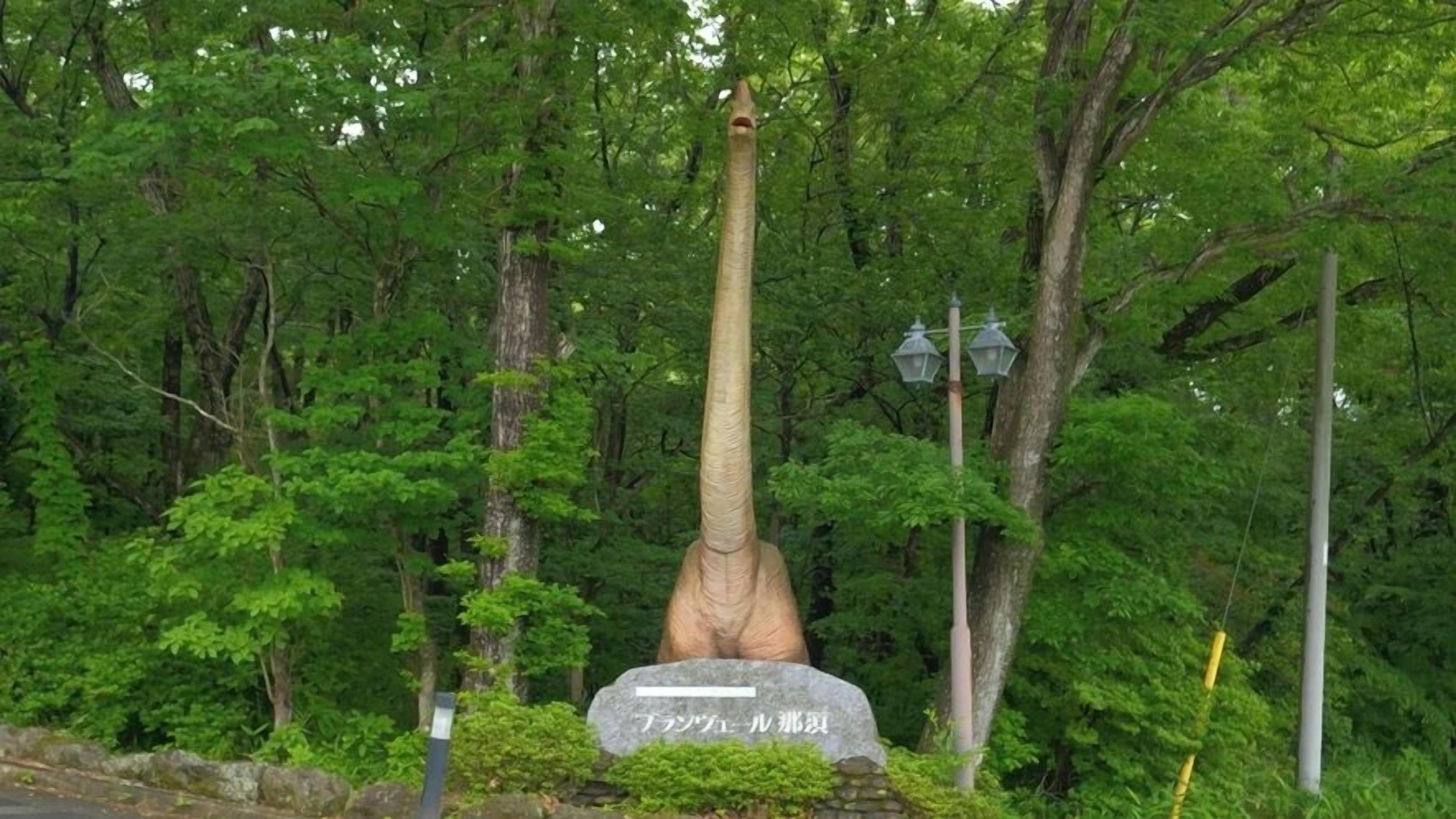 Um monumento alto e esguio, rodeado por vegetação exuberante.