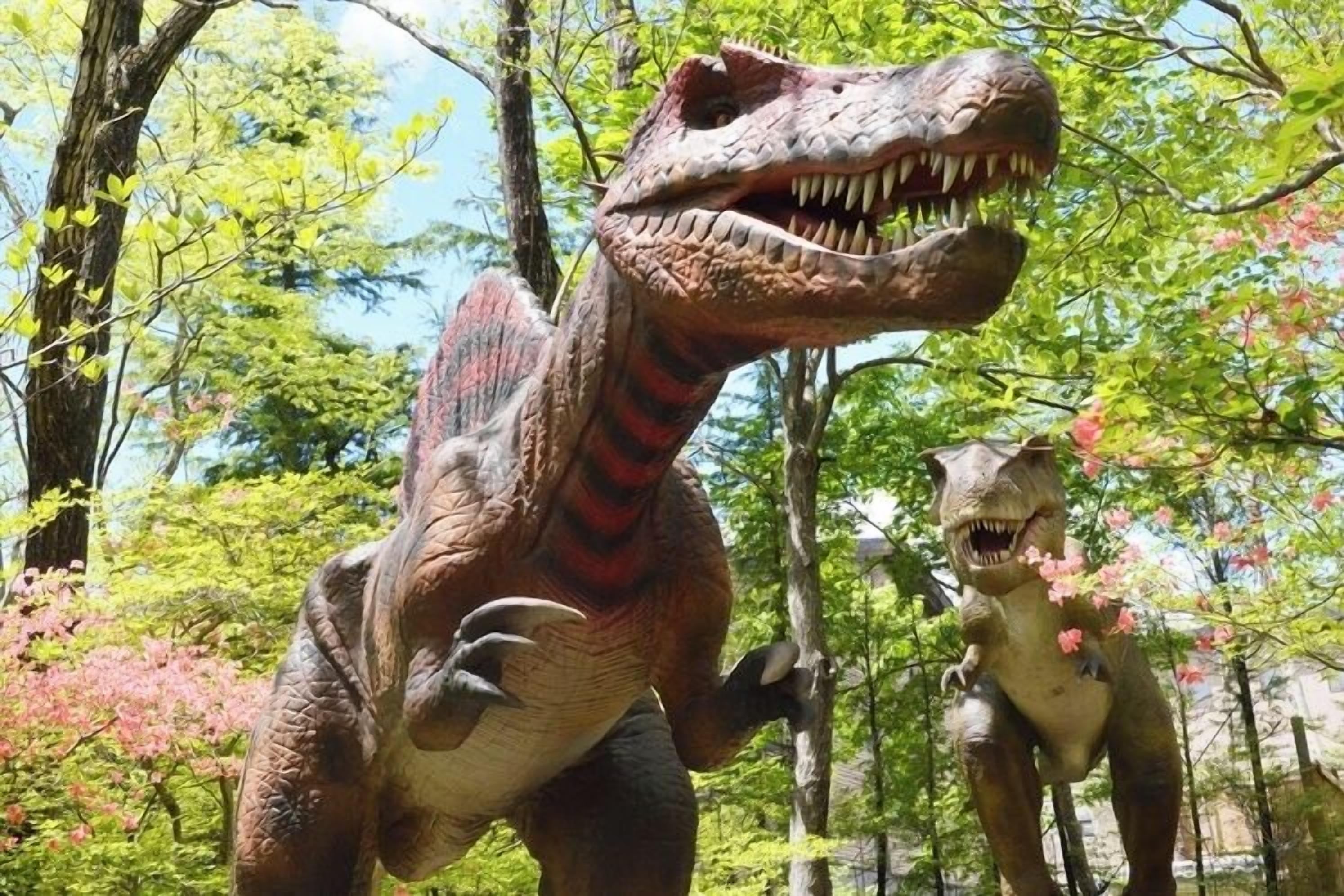 Una estatua de dinosaurio en un área boscosa.