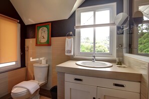 Et badeværelse med toilet, håndvask og vindue.