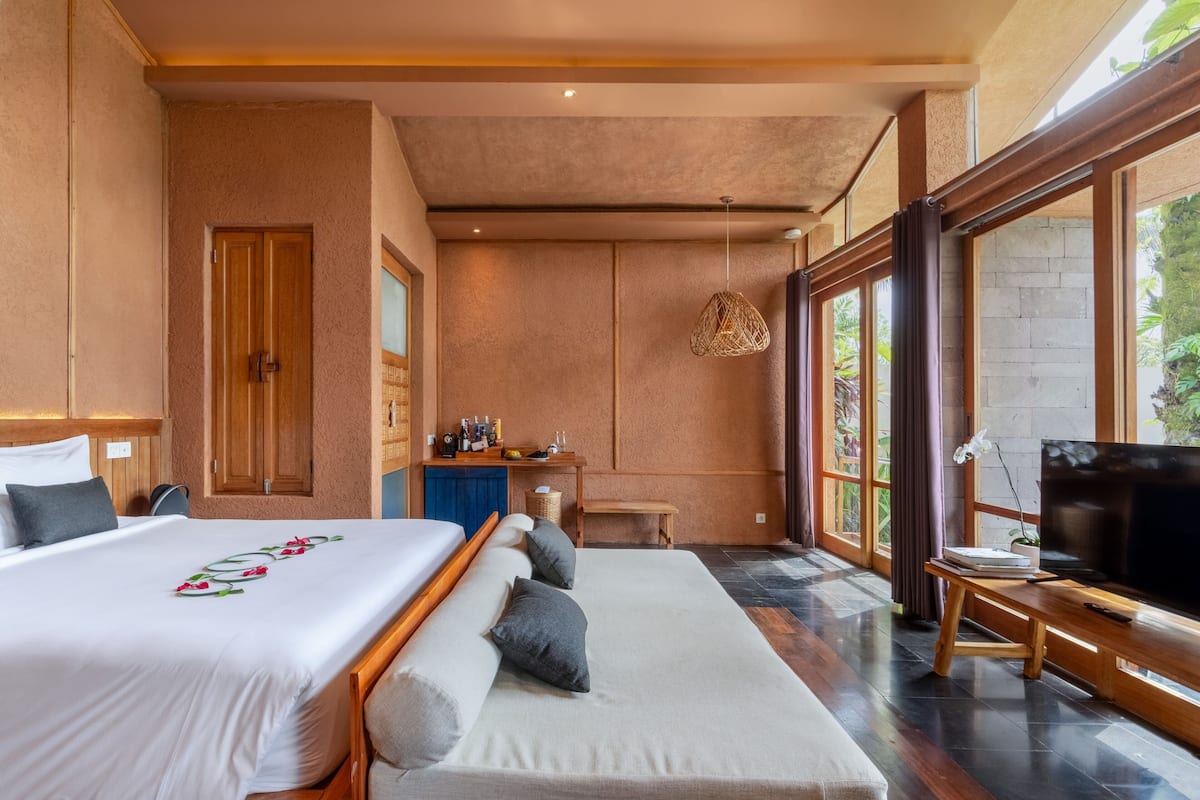 Un dormitorio con cama, televisor y escritorio.