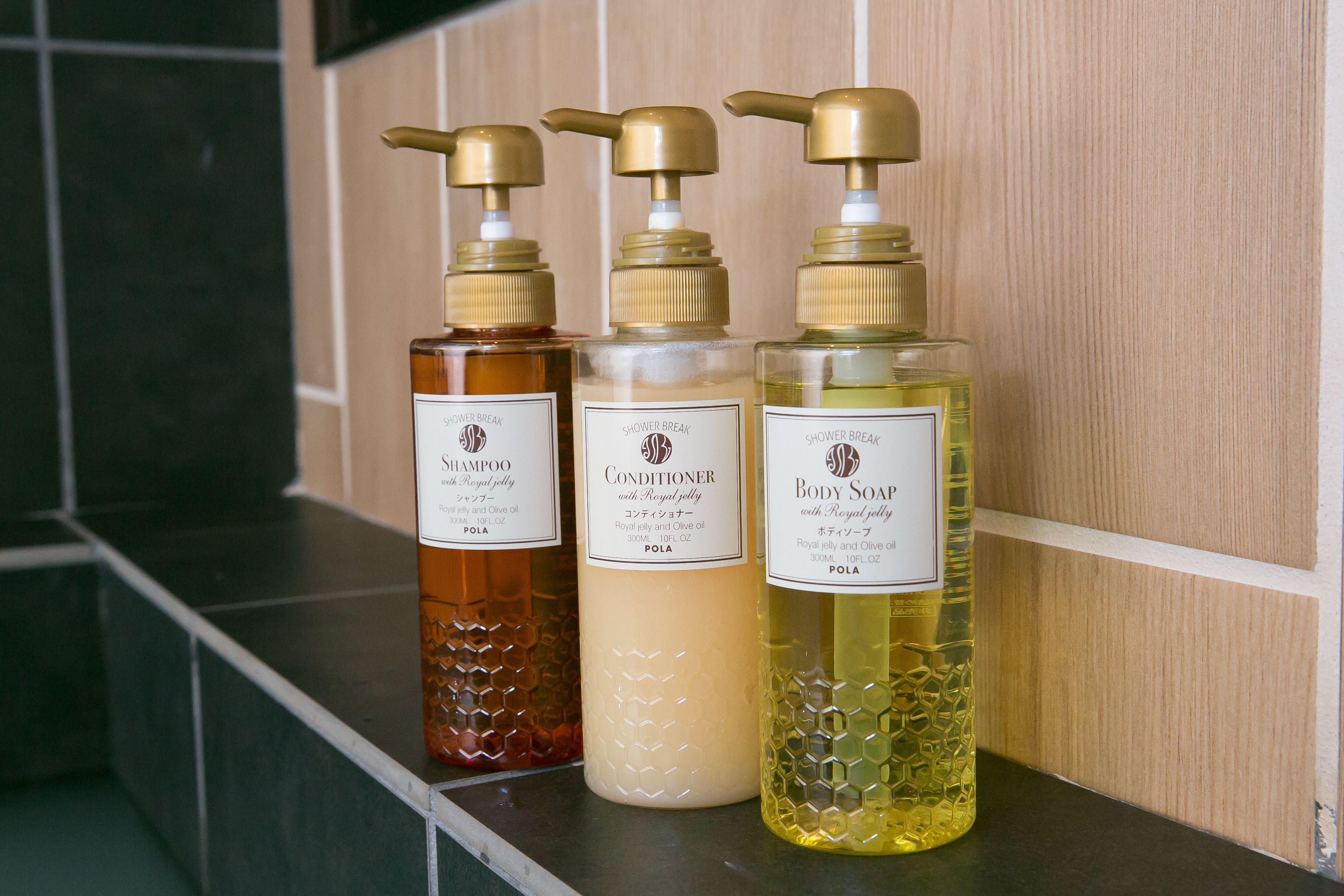 Three bottles of shower products on a shelf.