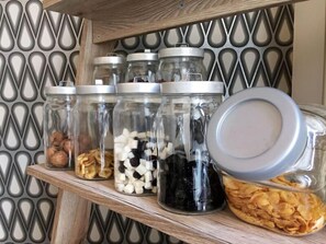 Une étagère avec des bocaux en verre contenant diverses collations.