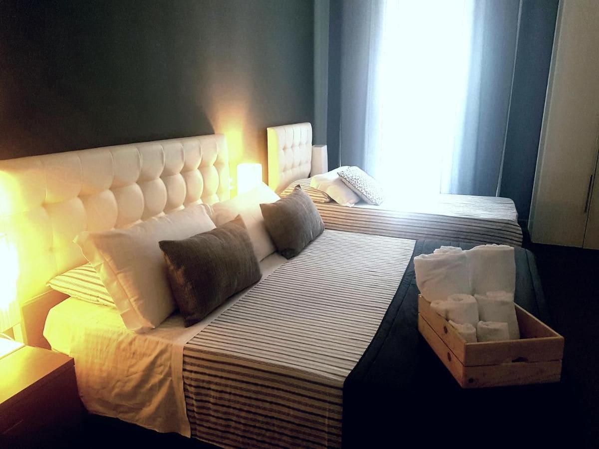 Una camera d'albergo con un letto grande, due comodini e un cofanetto di articoli da toilette in legno.
