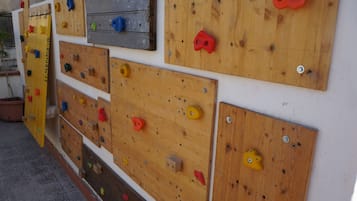 Un muro con diverse pareti artificiali in legno dotate di appigli colorati.