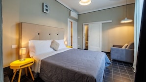 A hotel room with a bed, bedside table, lamp, and a chair. - Birbo Bike Hospitality (Siena)