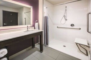 A modern bathroom with a shower, a sink, and a mirror.