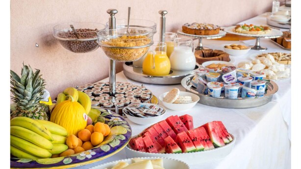 Un bufé con diversas frutas, cereales y productos lácteos.