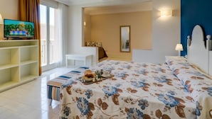 Una habitación de hotel con una cama, televisión, escritorio y silla.