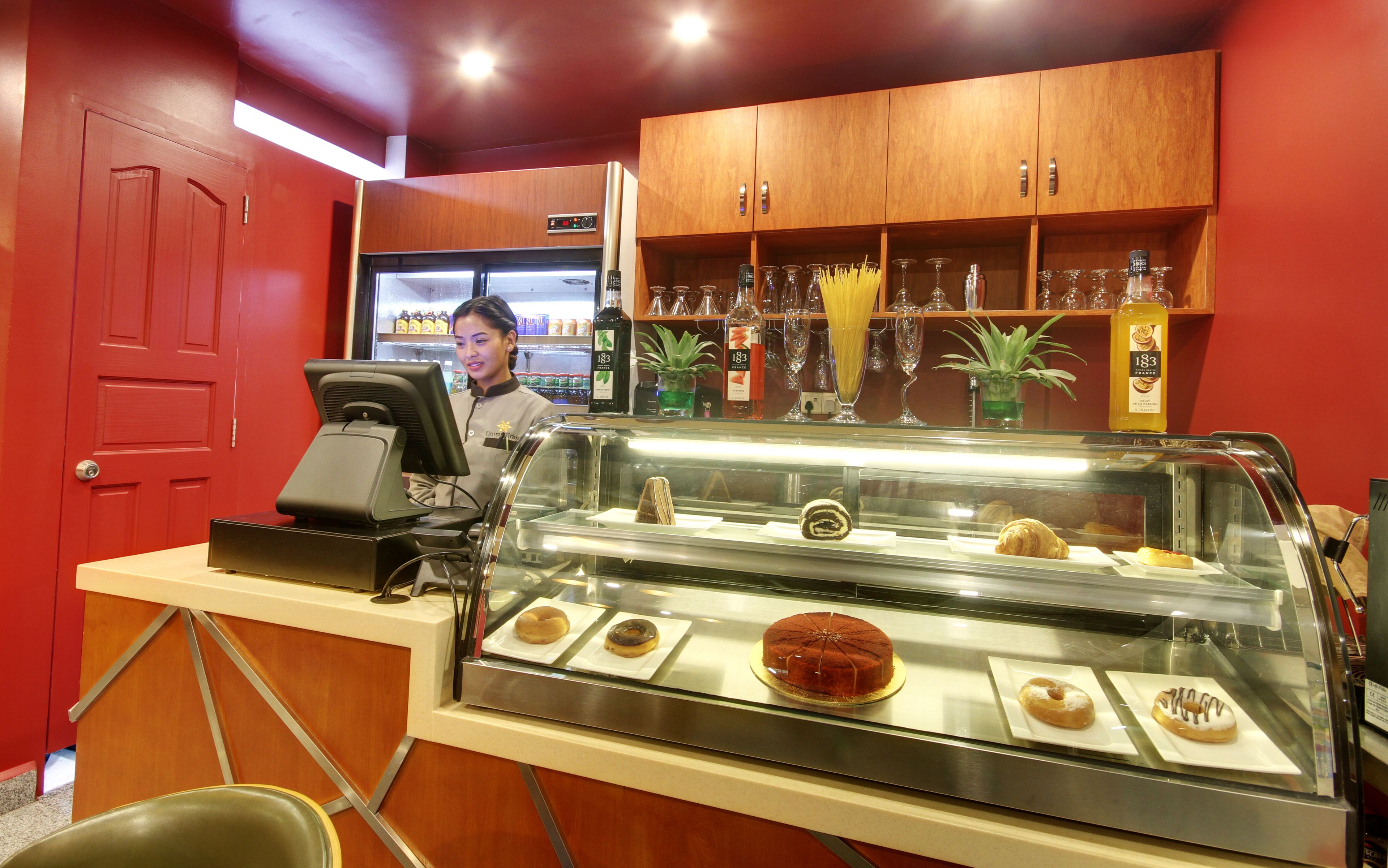 Un bancone di pasticceria con dolci e una macchina per caffè.