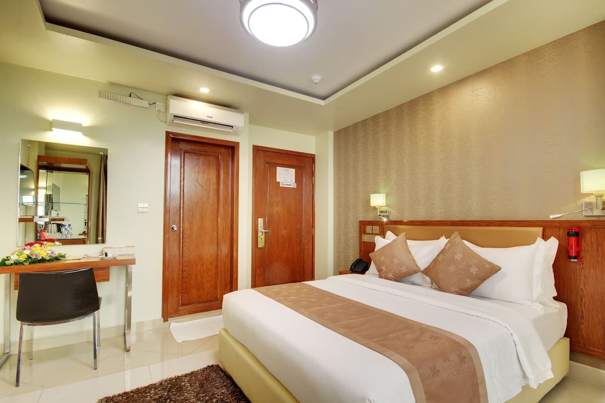 Une chambre d’hôtel équipée d’un lit, d’un bureau, d’une chaise et d’un appareil de climatisation.