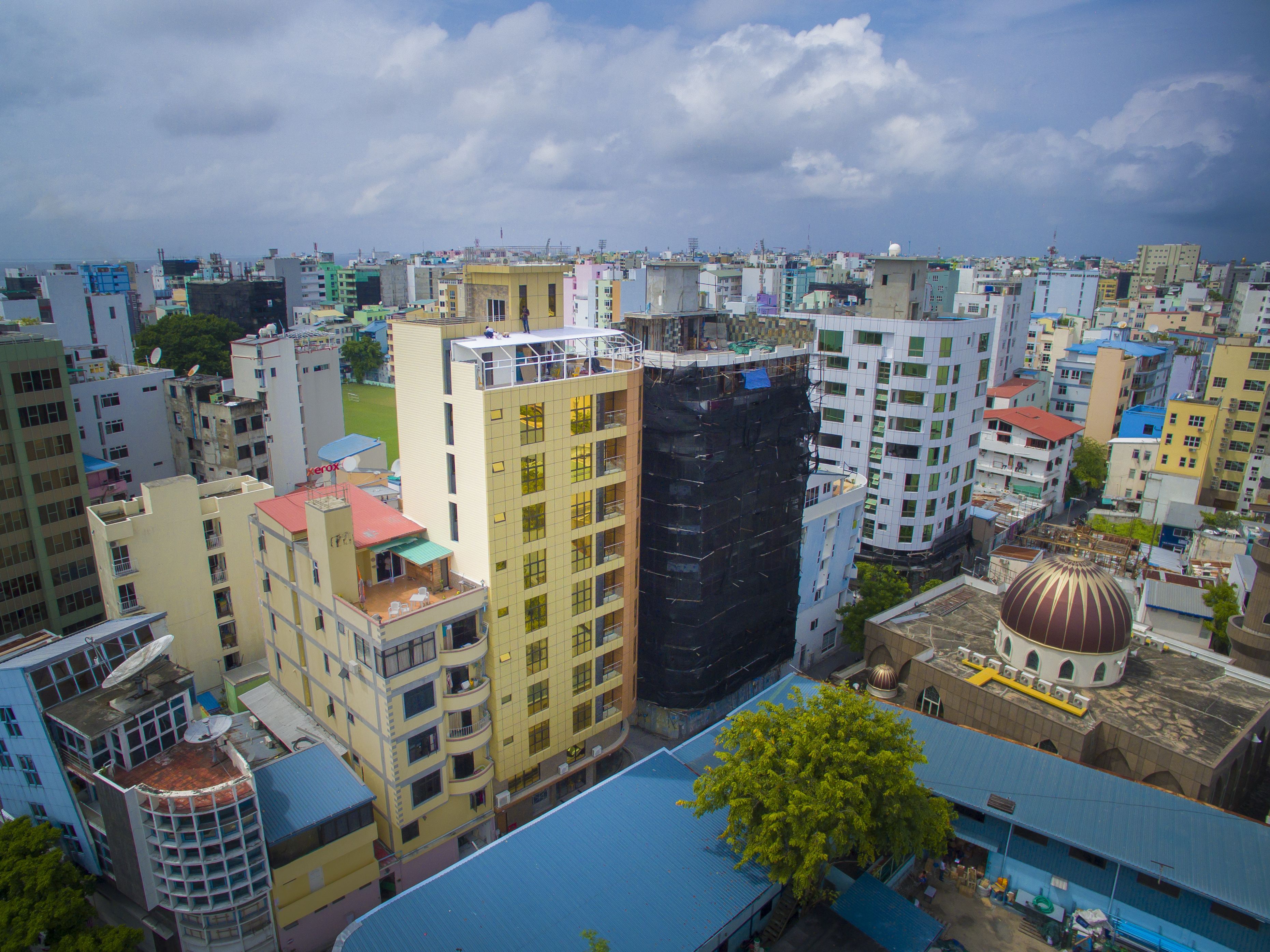 Una zona urbana densamente poblada con diversos edificios de varios pisos, algunos con balcones y antenas parabólicas.