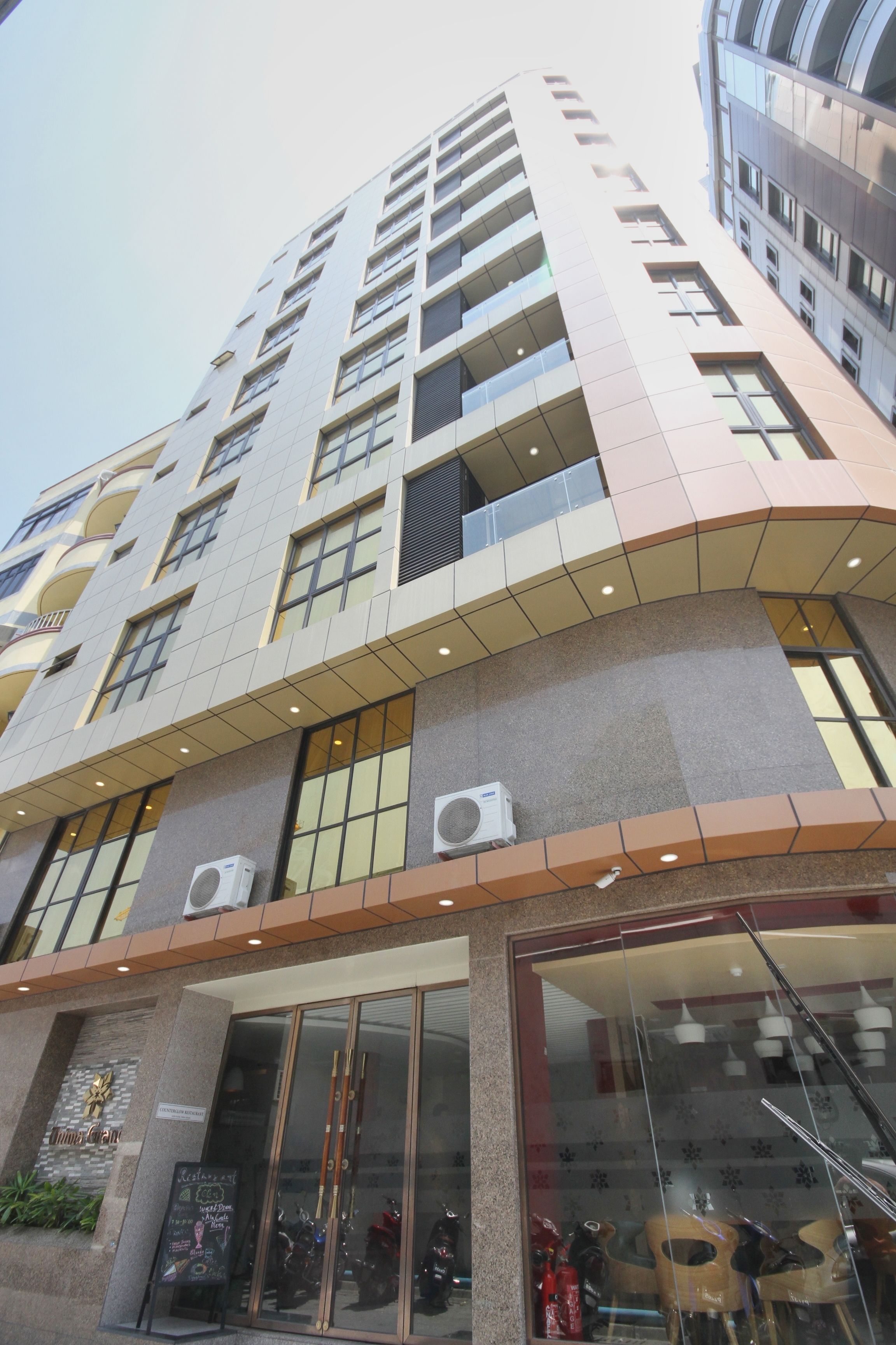 Ein mehrstöckiges Hotel mit modernem Design, ausgestattet mit großen Fenstern und Klimaanlagen an der Fassade.