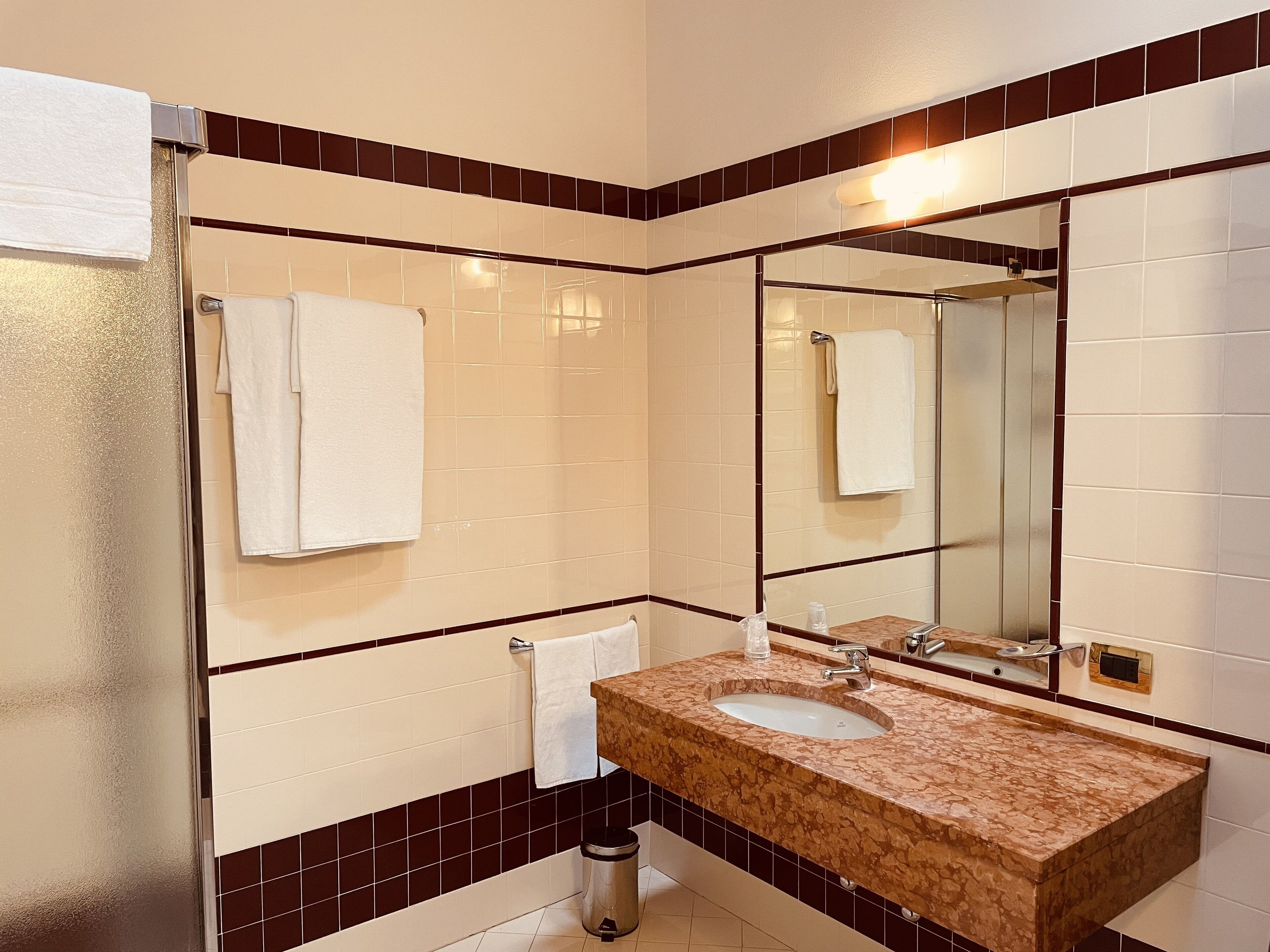 A bathroom with a sink, mirror, and towel rack.
