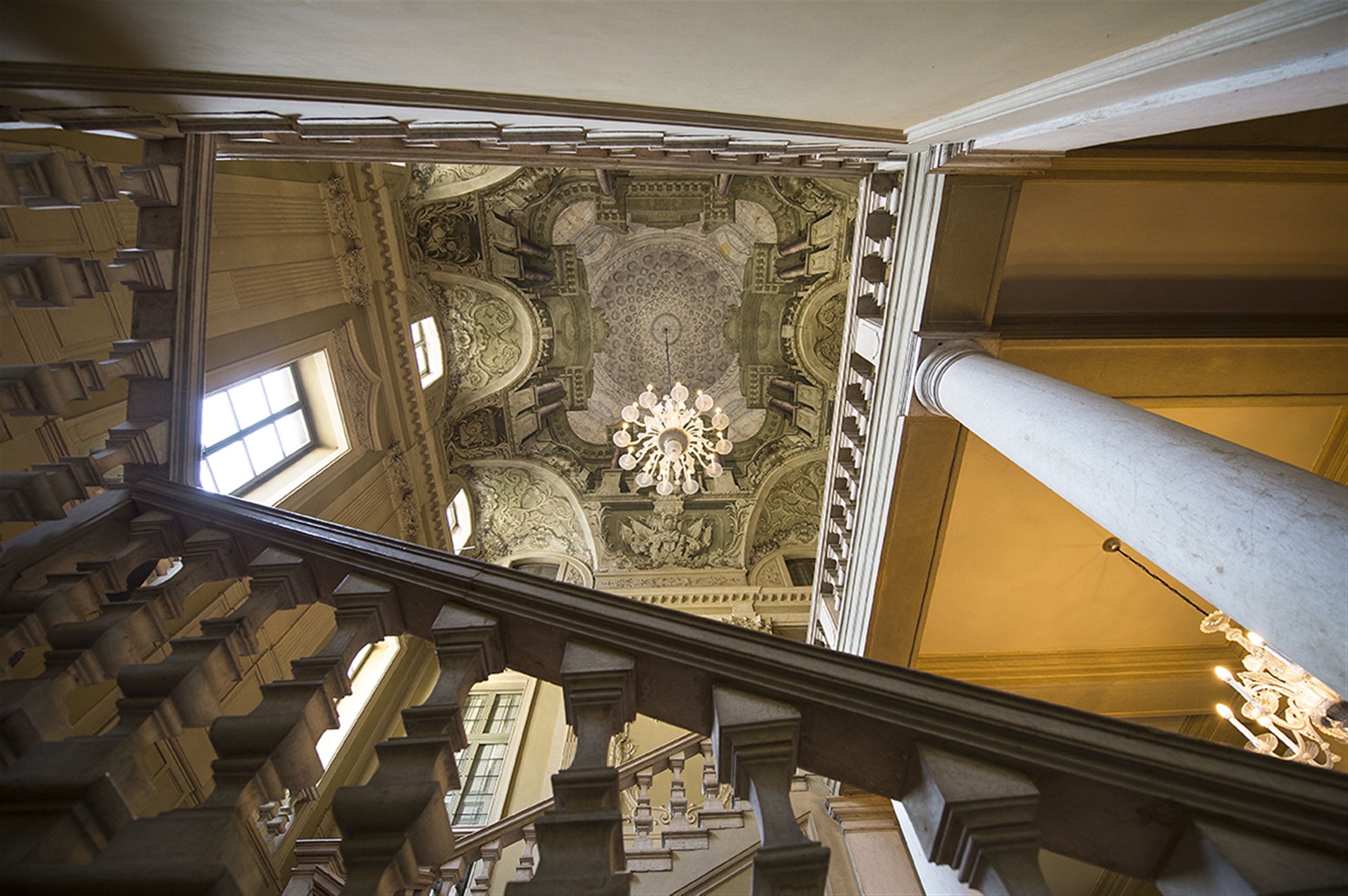 A grand staircase with ornate balustrades and a detailed ceiling.