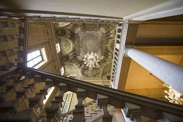 A grand staircase with ornate balustrades and a detailed ceiling.