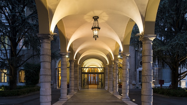 A covered walkway with stone columns and a central light fixture. - Centro Paolo VI (Brescia)