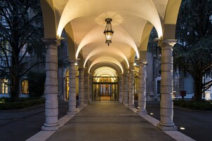 Une allée couverte, agrémentée de colonnes en pierre et d’un luminaire central.