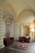Une pièce spacieuse avec deux canapés en cuir rouge, un tapis à motifs et une lampe.