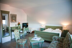 A hotel room with a bed, a desk, a chair, a small table, and a television. - Flair Hotel Reuner (Zossen)